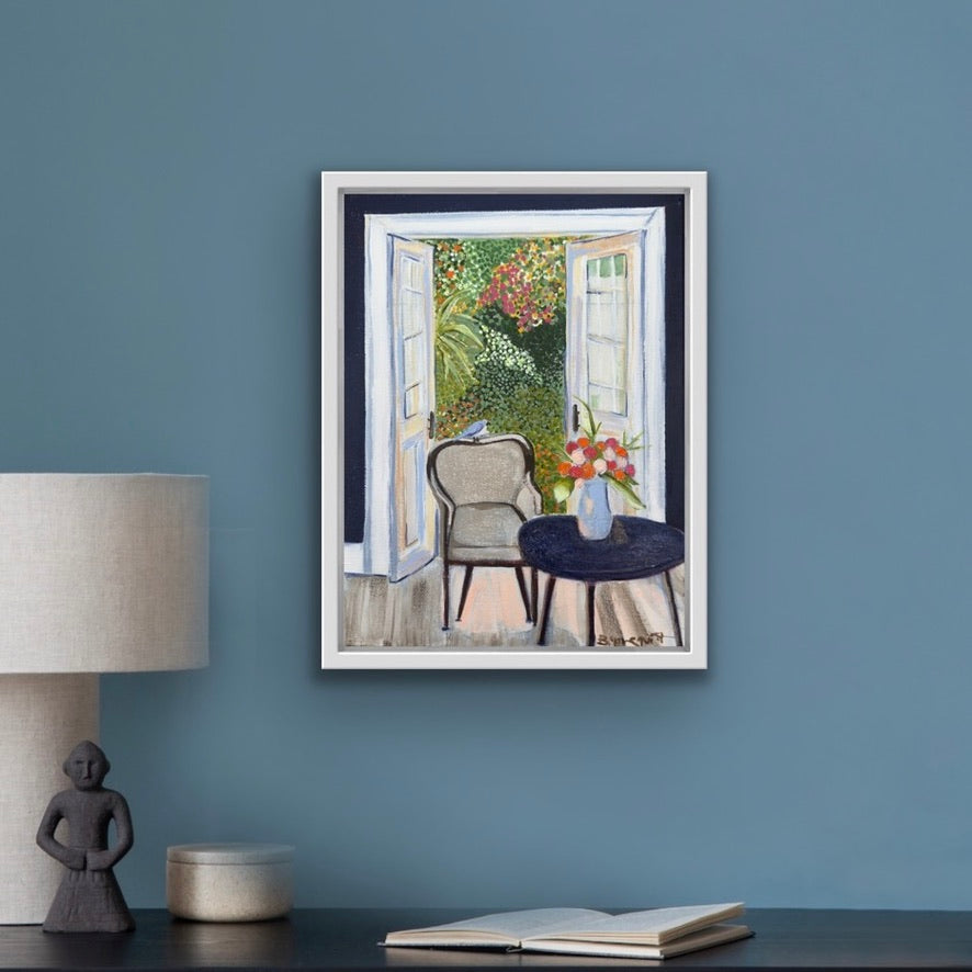 Framed artwork of a room with open french doors on a blue wall above a desk for home decor.