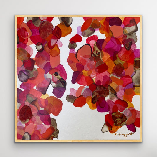 An abstract acrylic painting featuring warm hues of red, pink, and orange with collaged shapes on a white background, framed in a natural wood frame.