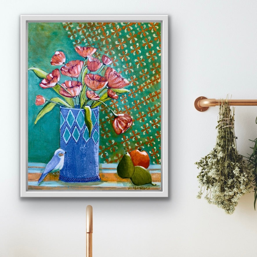 Framed artwork of a vase with flowers, bird, and pears on a decorative wall.
