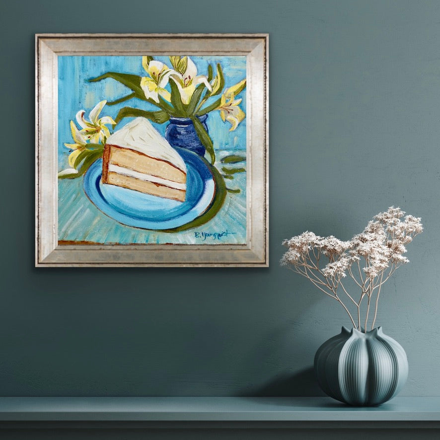 Framed painting of a slice of cake and flowers on a blue plate, with a vase of white flowers on a shelf below for art collectors and home decor