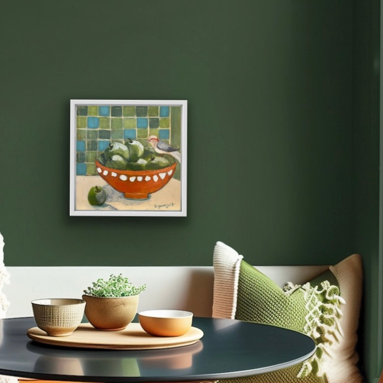 Framed artwork on a green wall above a table with decorative items for interior design and home decor.